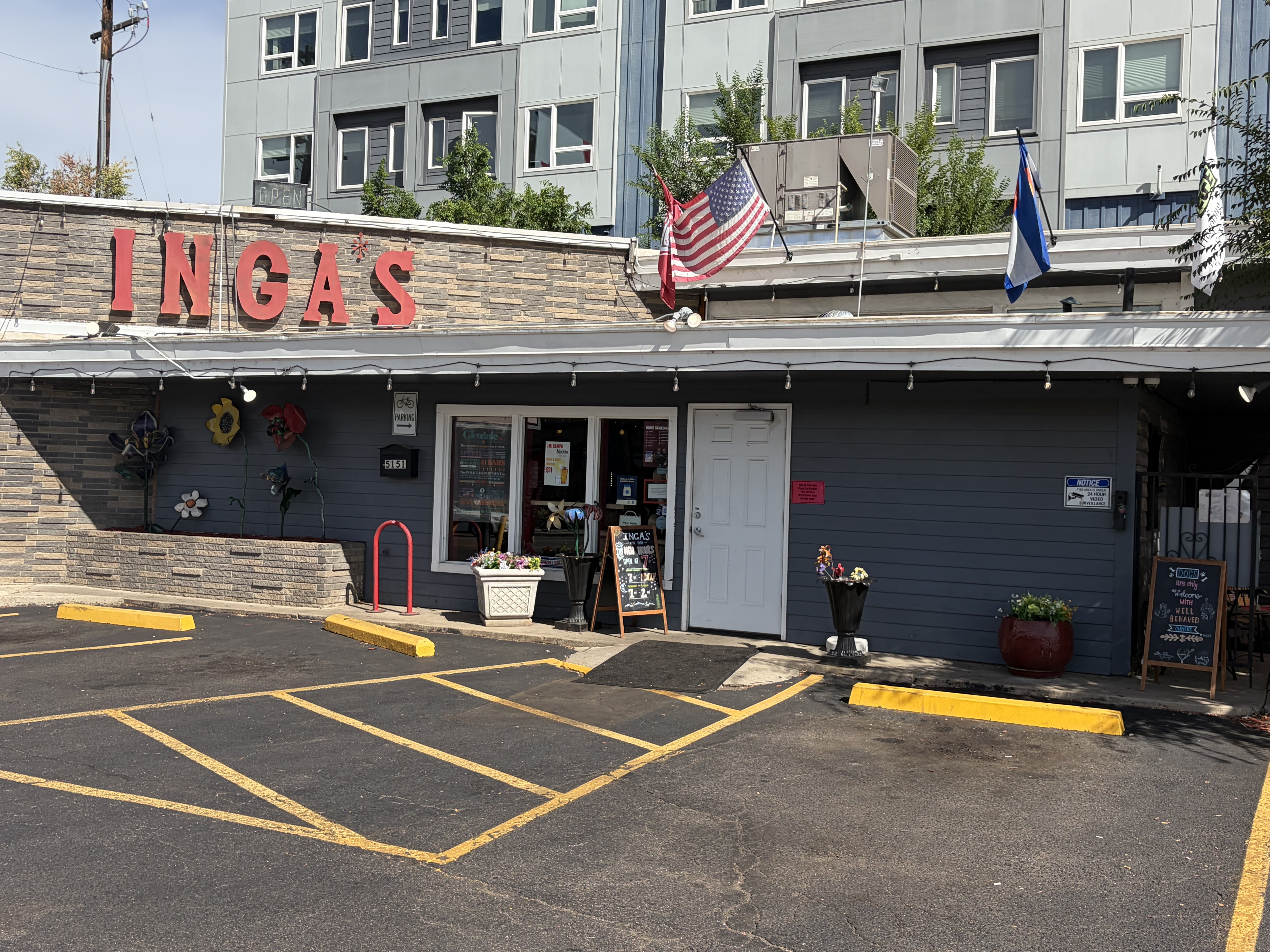 Inga's storefront on Leetsdale Drive with red letters, a Colorado flag and an open sign.