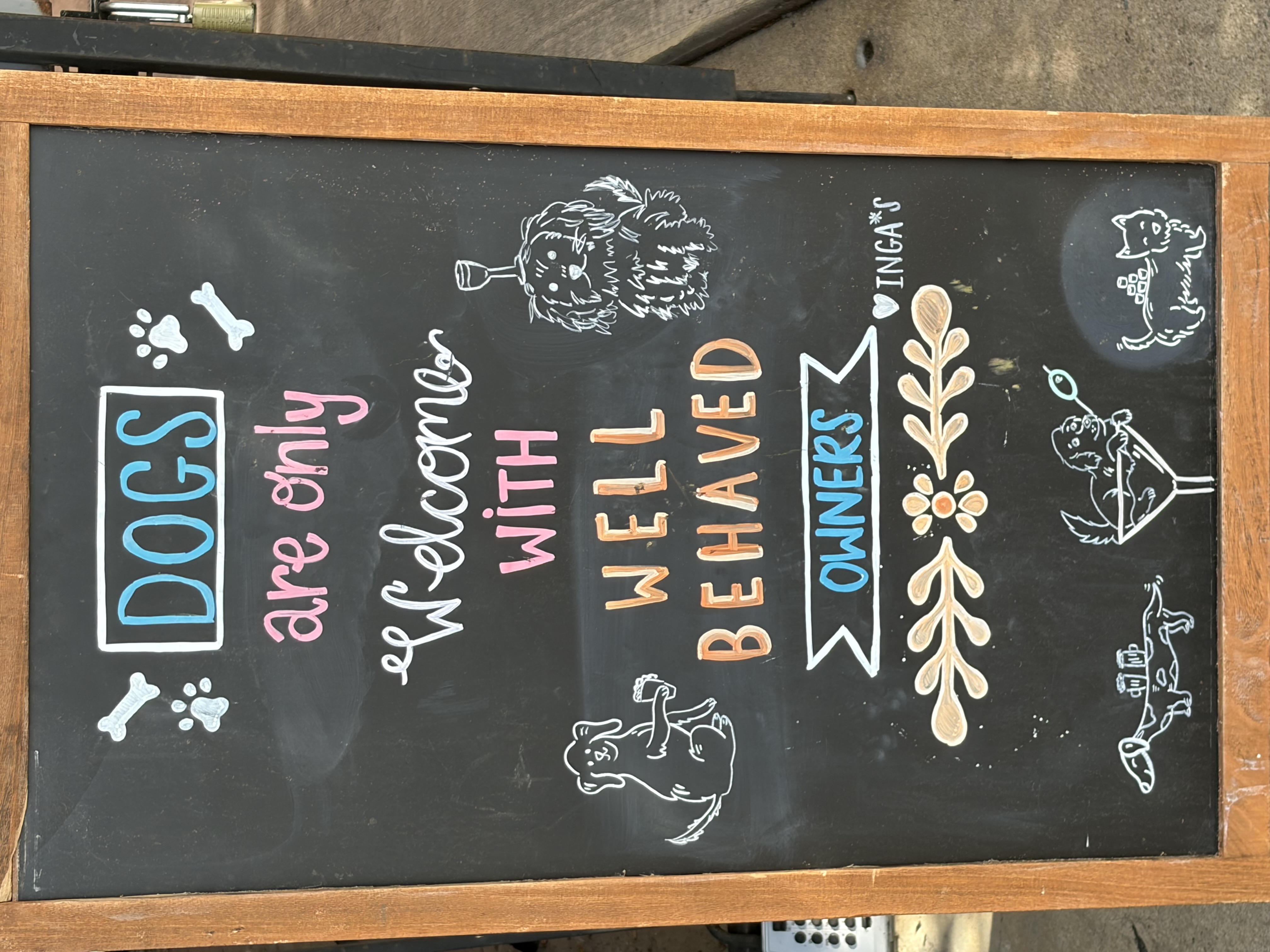 A chalkboard reading: dogs are only welcome with well behaved owners.